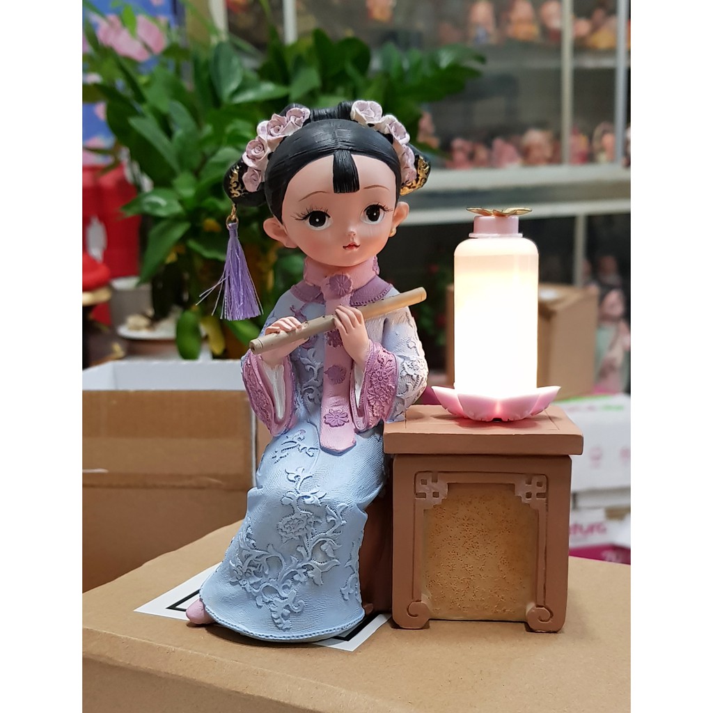Tượng thiếu nữ thổi sáo bên đèn